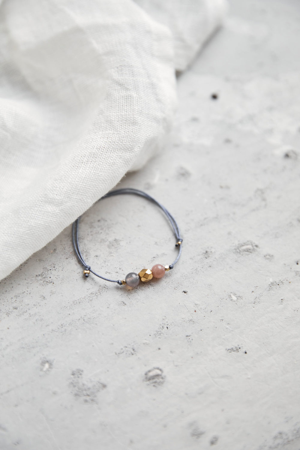 KEOKEA Armband verstellbares Schiebearmband mit Achat und Mondstein rosé Steinen und goldener Perle. Tuch.